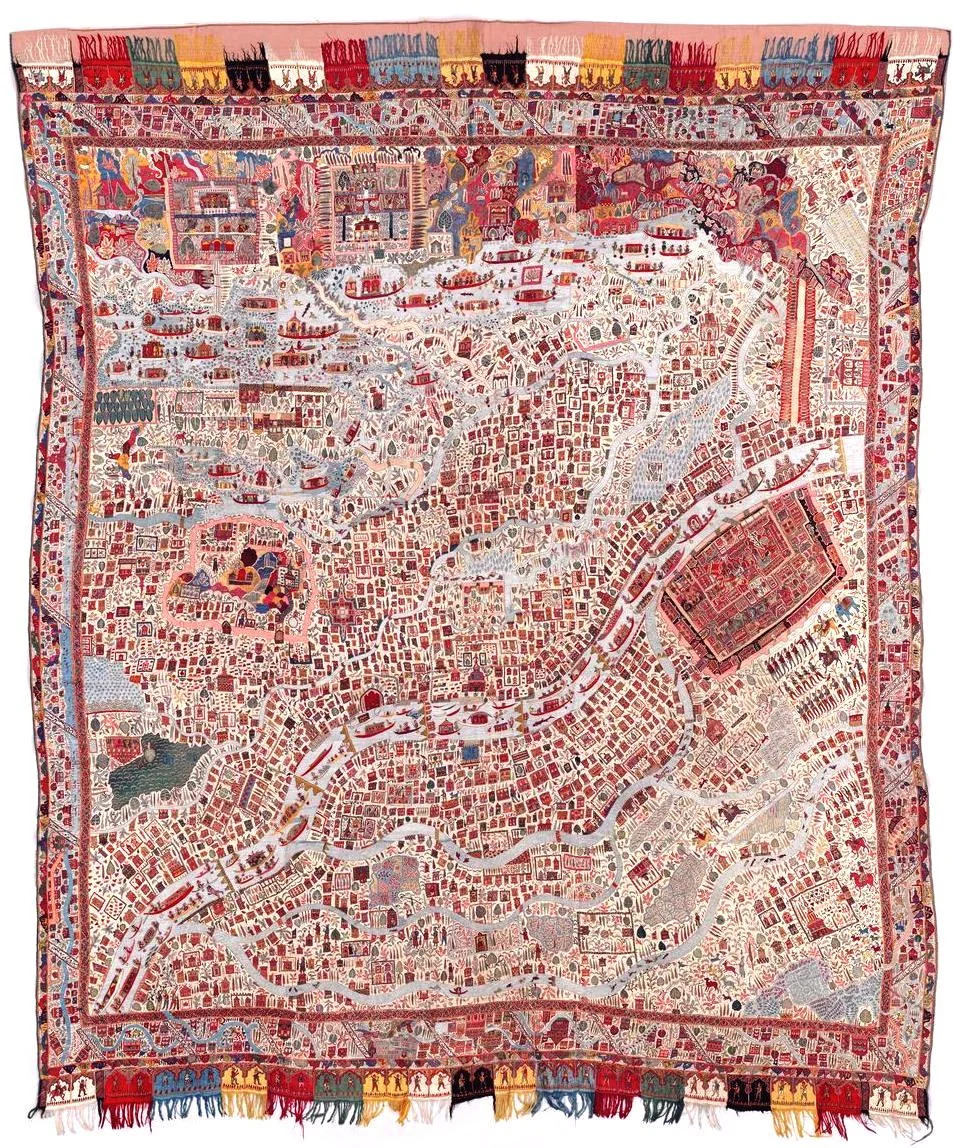 Shawl embroidered with multi-coloured wools with a pictorial map of Srinagar. The background consists of rectangles of twill-weave wool, seamed together. On this ground the embroidery has been worked in fine wools, mainly in darn-stitch, satin stitch and stem-stitch, creating on the surface the effect of a woven design. An embroidered Persian inscription is set at regular intervals round the border, and further inscriptions are scattered among the buildings.